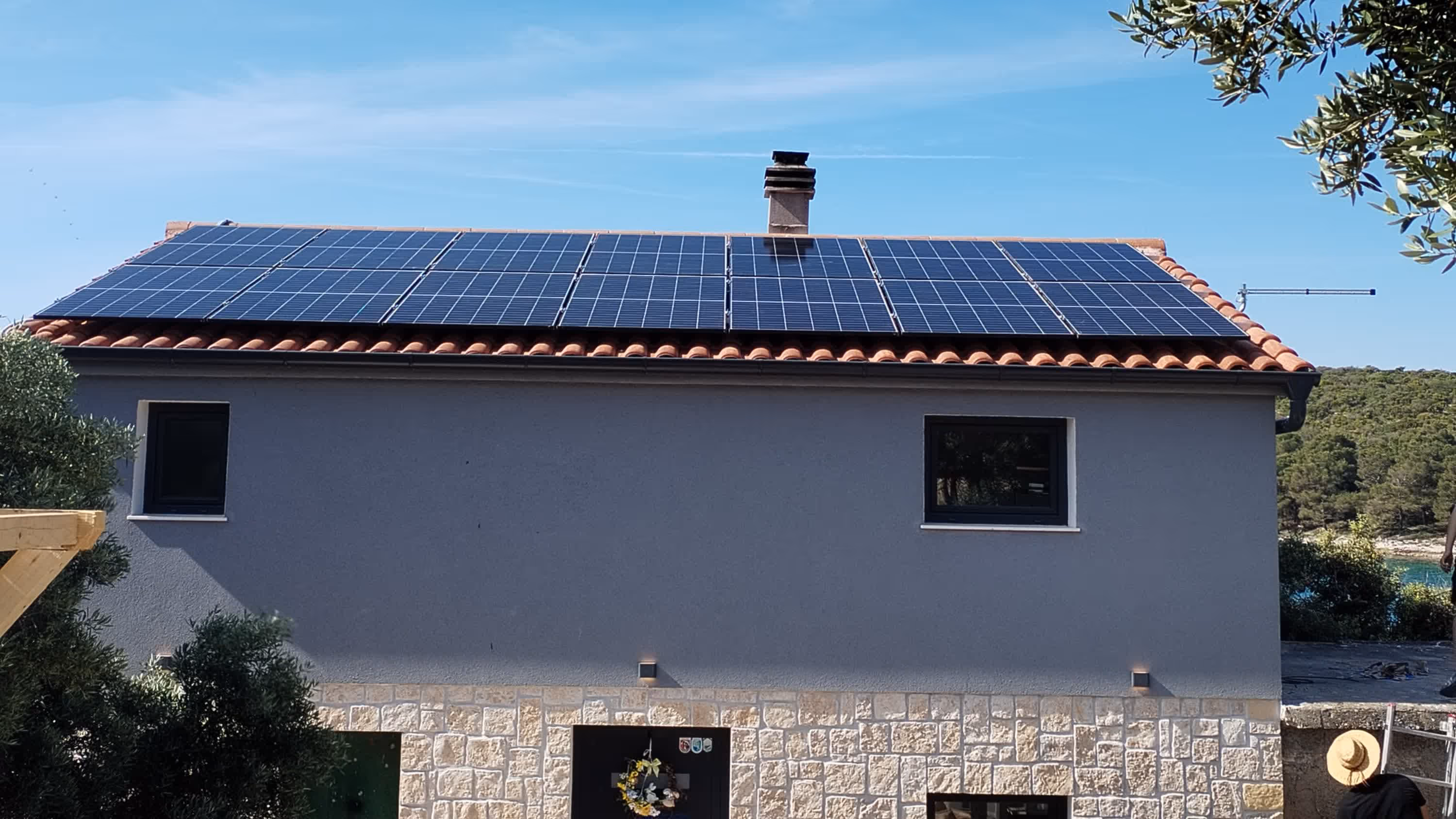 Solarni paneli na krovu objekta u zlatnom svjetlu zalaska sunca