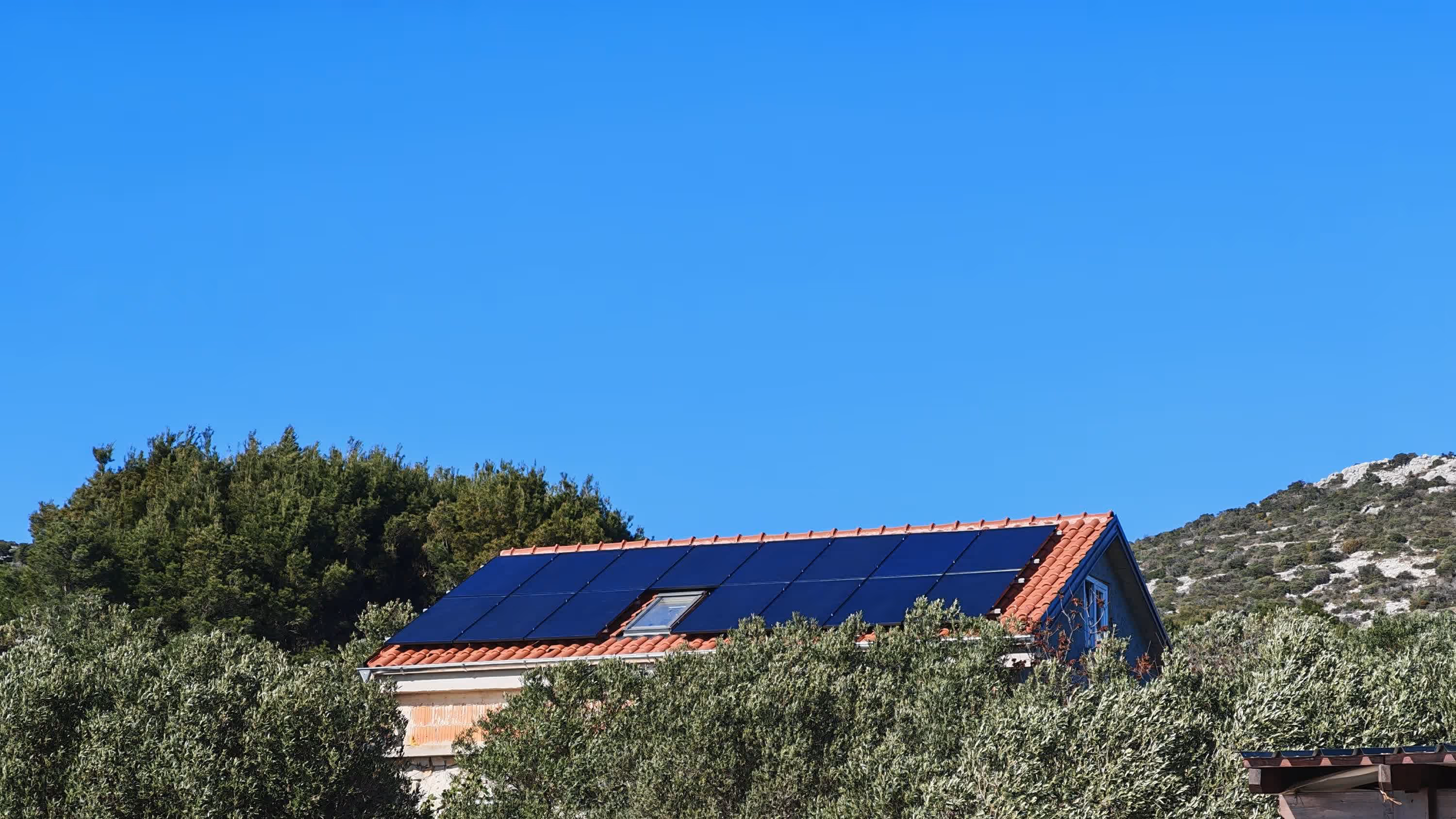 Solarni paneli na krovu objekta u zlatnom svjetlu zalaska sunca