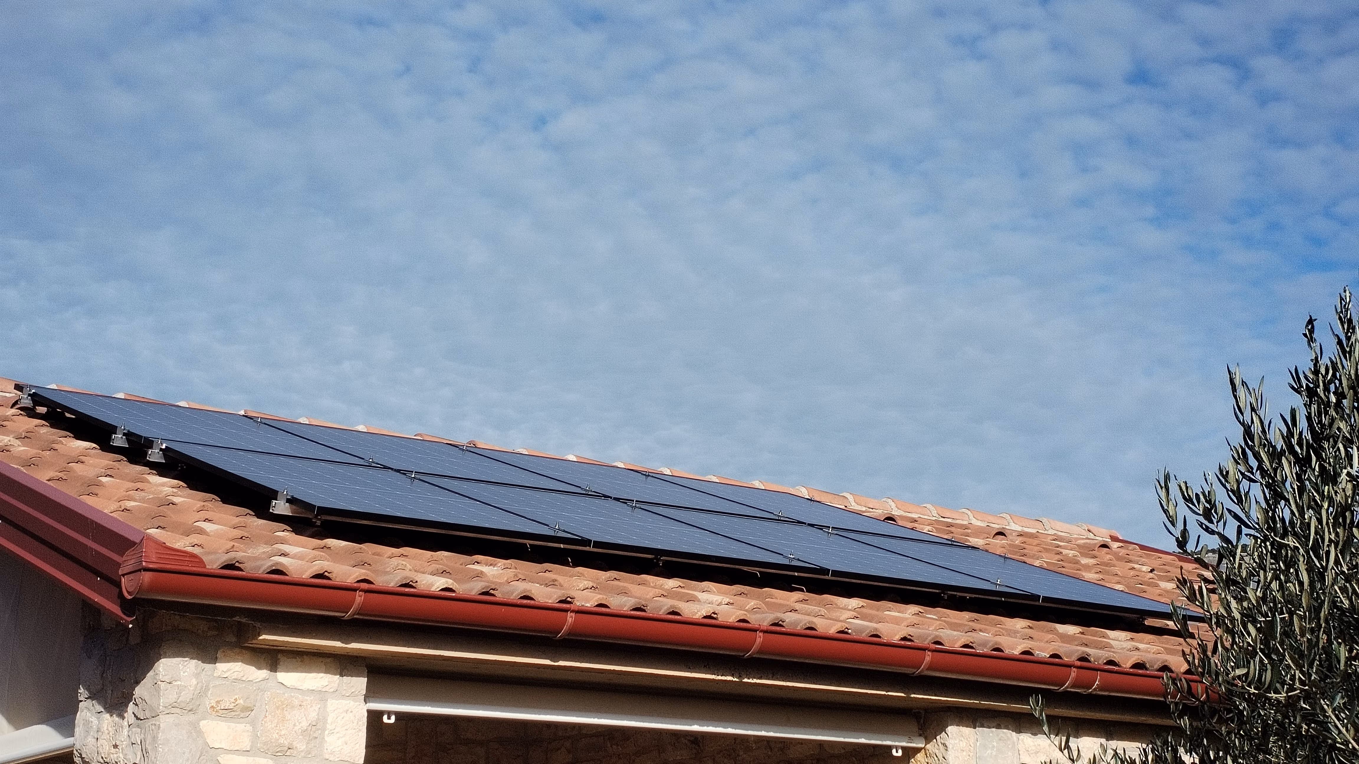 Solarni paneli na krovu objekta u zlatnom svjetlu zalaska sunca