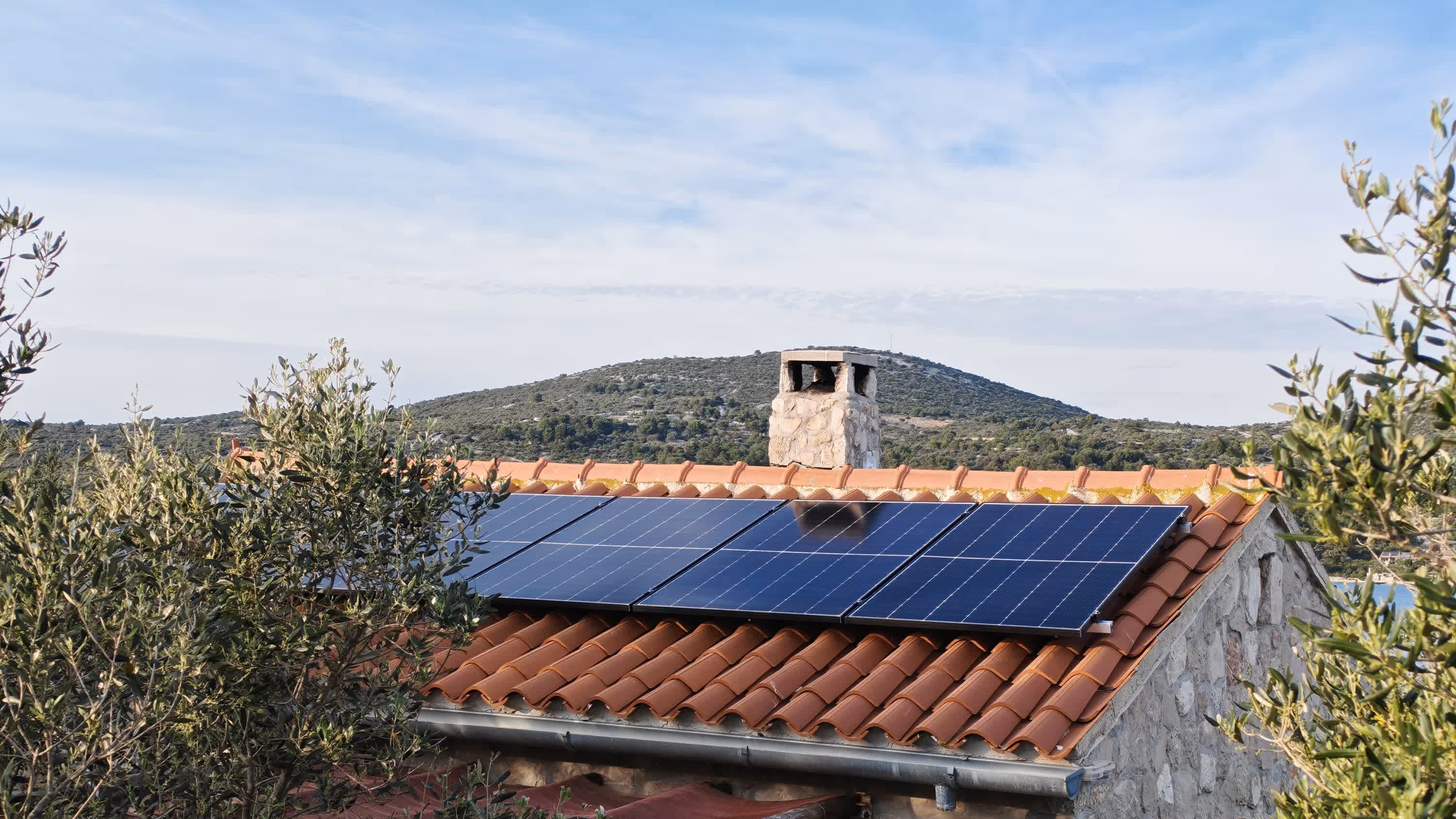 Solarni paneli na krovu objekta u zlatnom svjetlu zalaska sunca